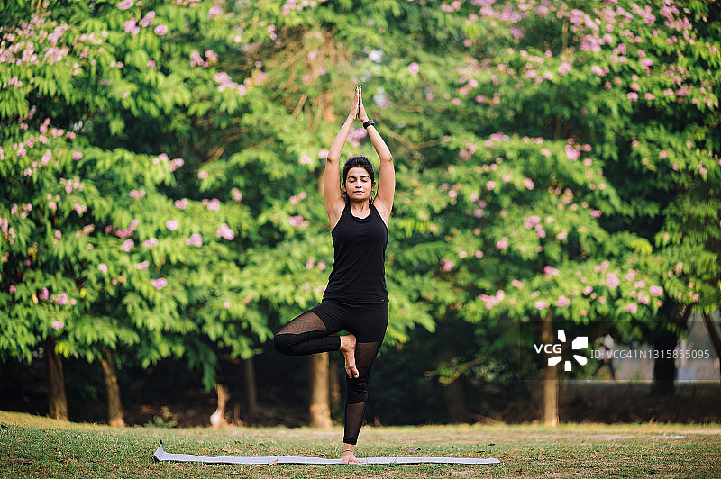 年轻女人在公园练习瑜伽和晨练图片素材