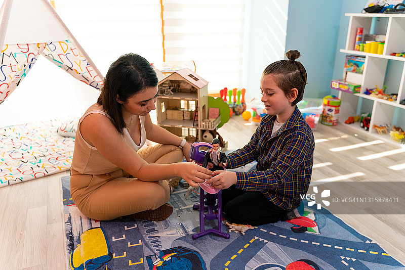 儿童职业治疗：小男孩在治疗师的帮助下进行感官游戏图片素材