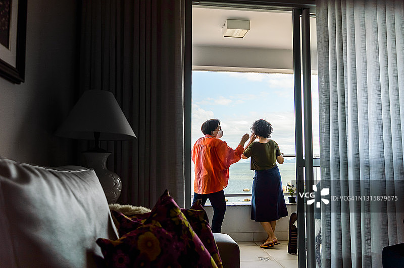 戴着面膜在阳台上放松的母女图片素材