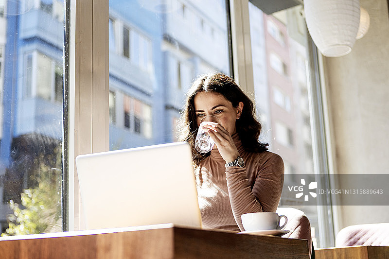 早上用笔记本电脑工作，享受咖啡图片素材