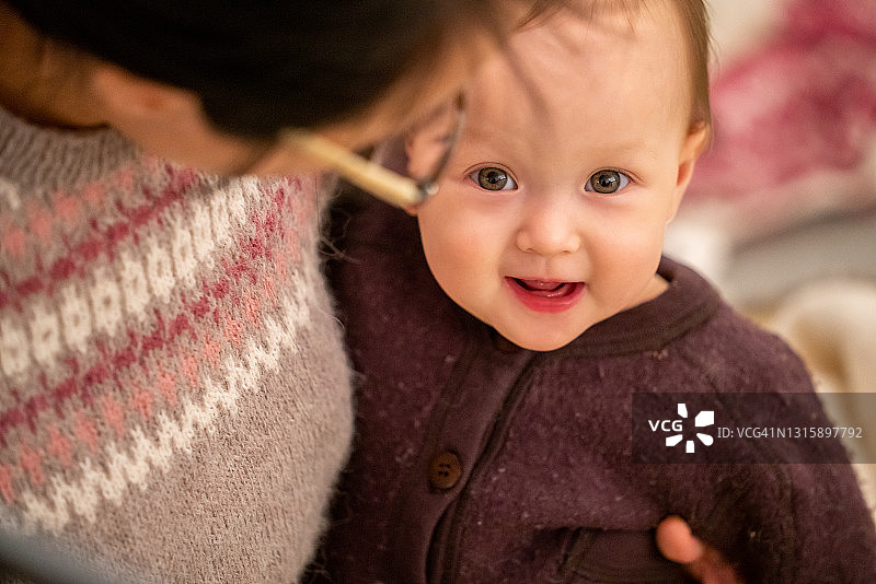 笑容满面女婴被妈妈拥抱图片素材