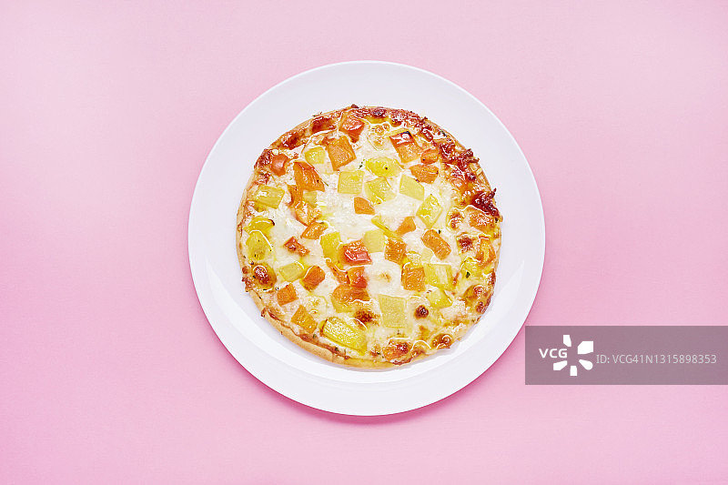 粉色背景盘子上小披萨的高角度视图图片素材