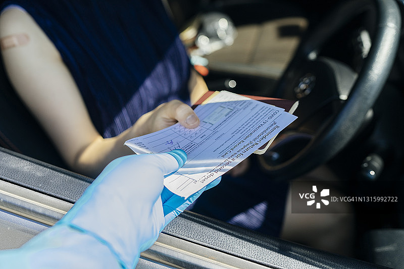 工作人员检查年轻旅客疫苗通行证图片素材