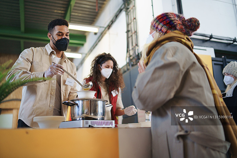 志愿者在救济厨房提供食物，贫困与新冠病毒概念图片素材