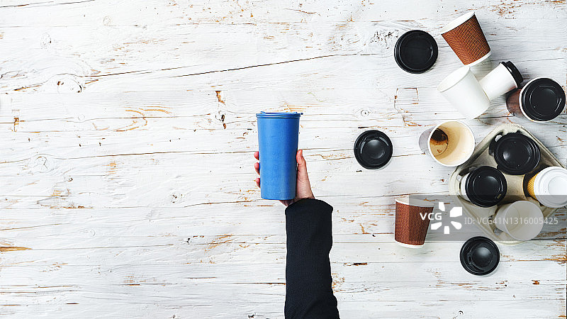 手持可重复使用咖啡杯的女士俯视图，可持续生活图片素材