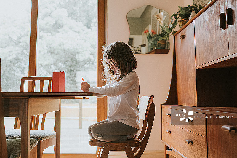 坐在桌旁向下看的小女孩图片素材