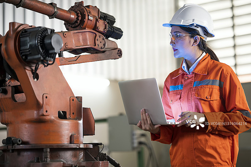 机器状态监测与预测性维护概念。在汽车行业工作的亚洲女性工业工程师，她精通工业应用中的机器人弧焊传感器和编程。图片素材