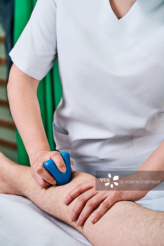 理疗师在诊所治疗患者小腿图片素材