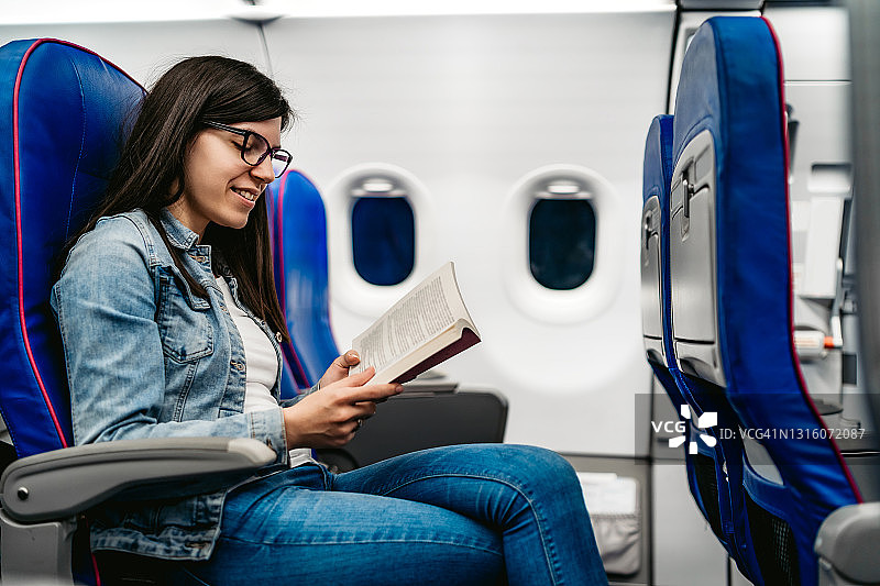 女人在飞机上阅读图片素材