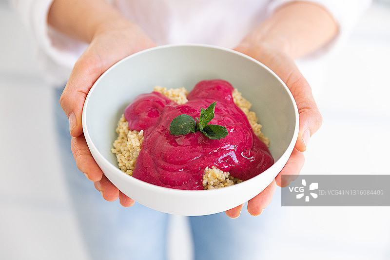 年轻女人准备早餐谷物碗图片素材