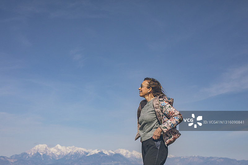 早晨，女徒步者在山顶观景点放松身心图片素材