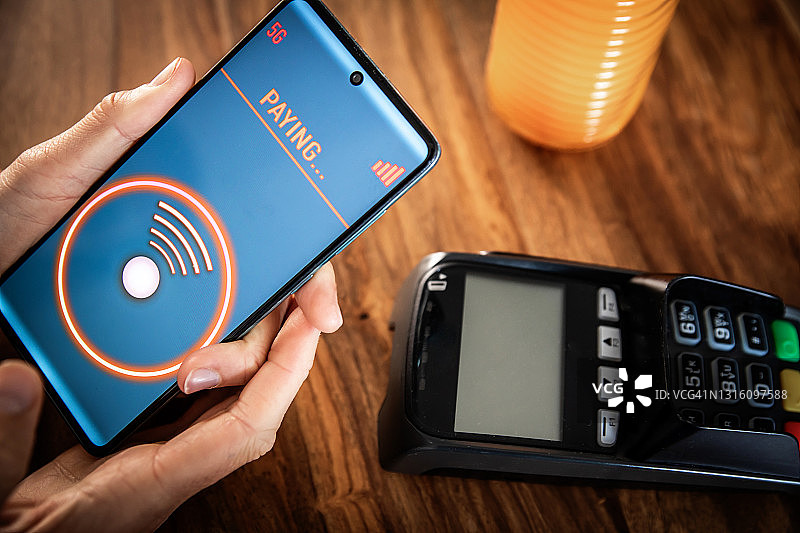 在餐厅使用智能手机进行非接触式支付图片素材