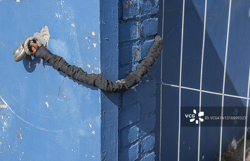 塑料布覆盖的带锁黑色链条图片素材