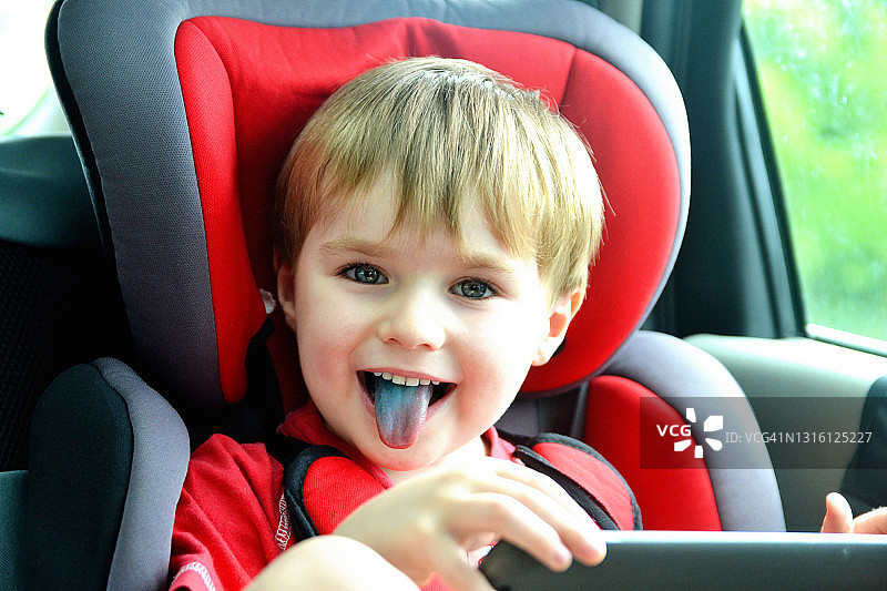 车里伸出蓝色舌头的小男孩图片素材
