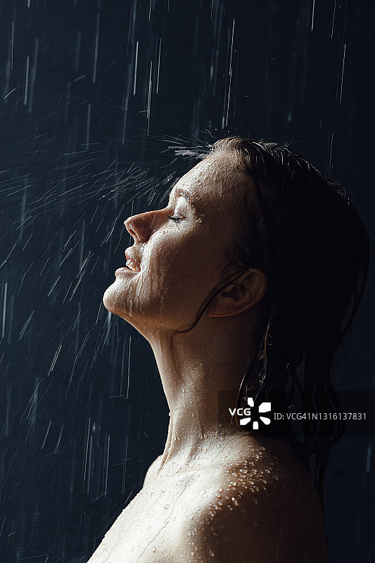 淋浴中的年轻欧洲女人特写，抬头看水滴落在脸上图片素材