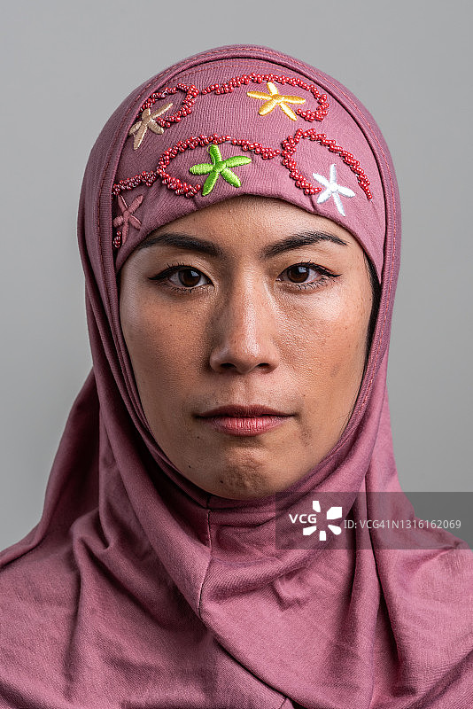表情严肃的中年亚洲穆斯林女性看着镜头图片素材