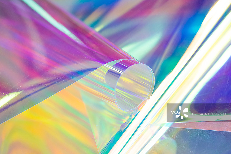 全息彩虹色布上的玻璃杯图片素材