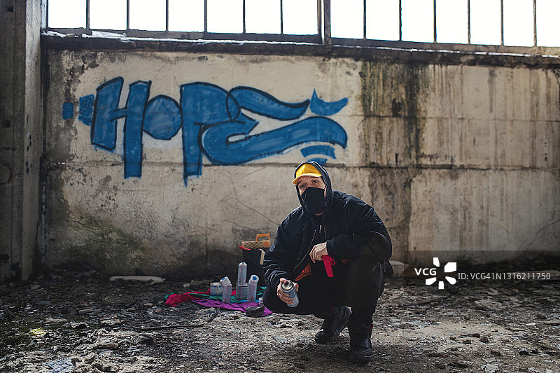 街头艺术家站在他的涂鸦前图片素材