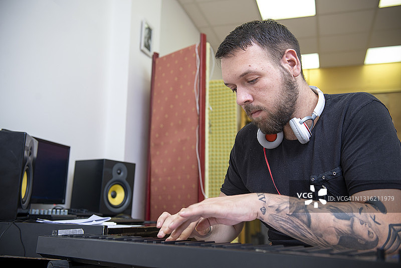 男人在音乐工作室弹钢琴图片素材