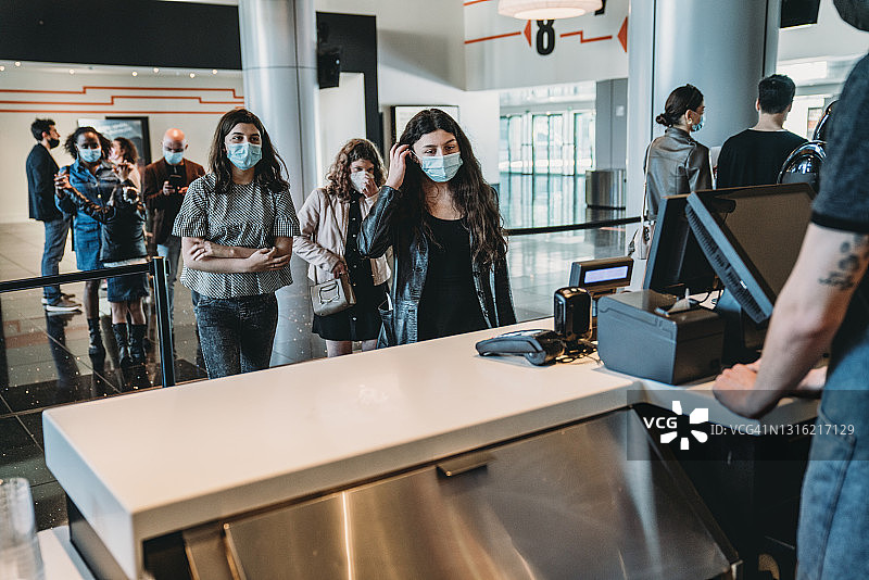 人们在电影院的酒吧点饮料和食物图片素材