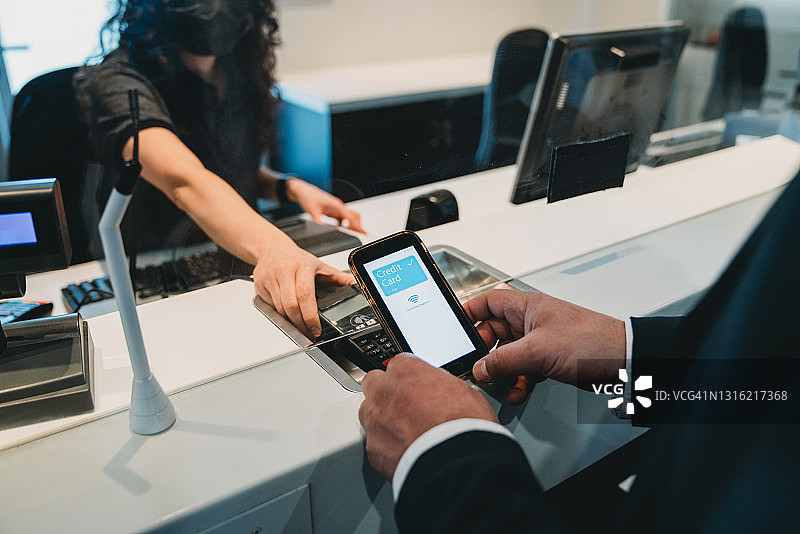 男人使用手机信用卡应用程序通过非接触式技术进行支付图片素材