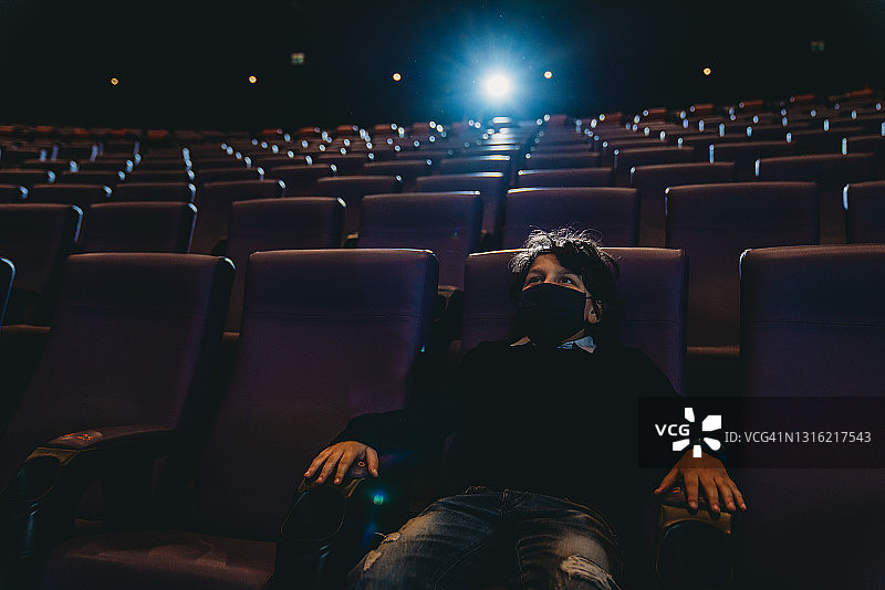 在电影院观看电影的男孩图片素材