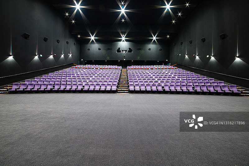 空旷的大电影院，有许多排紫色座位图片素材