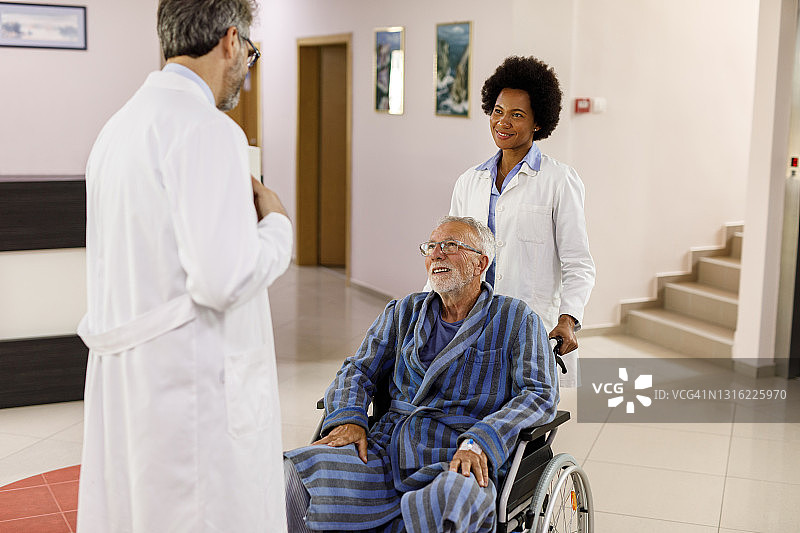 医务人员与轮椅上的老年男子交谈图片素材