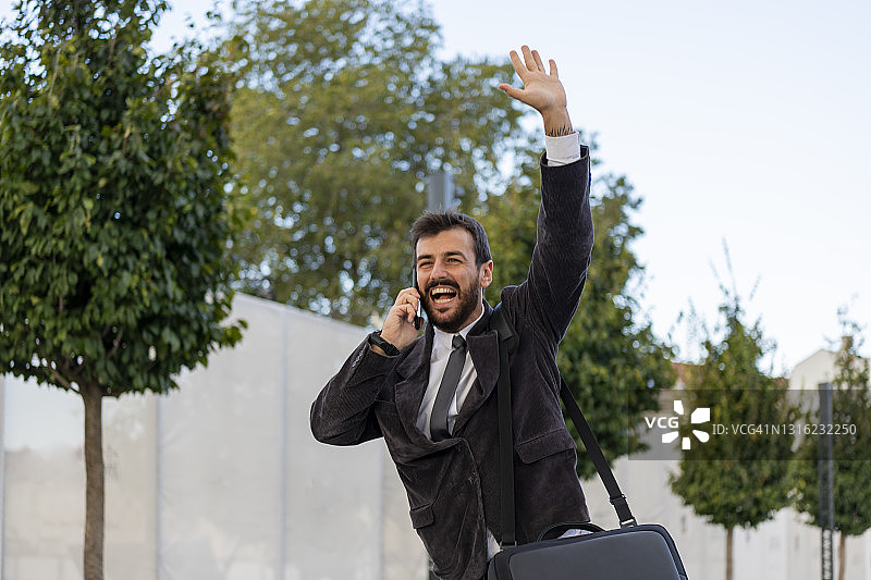 街头年轻商人赶路打车，电话联系伙伴图片素材