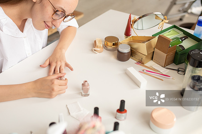 年轻女人在家中卧室涂指甲图片素材