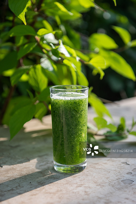 一杯黄瓜汁，户外自然绿色背景图片素材