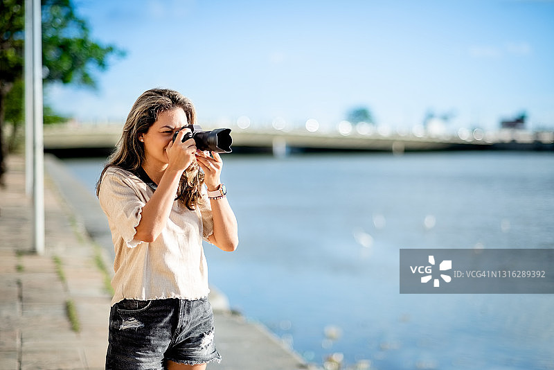 在户外使用相机拍摄的女人图片素材