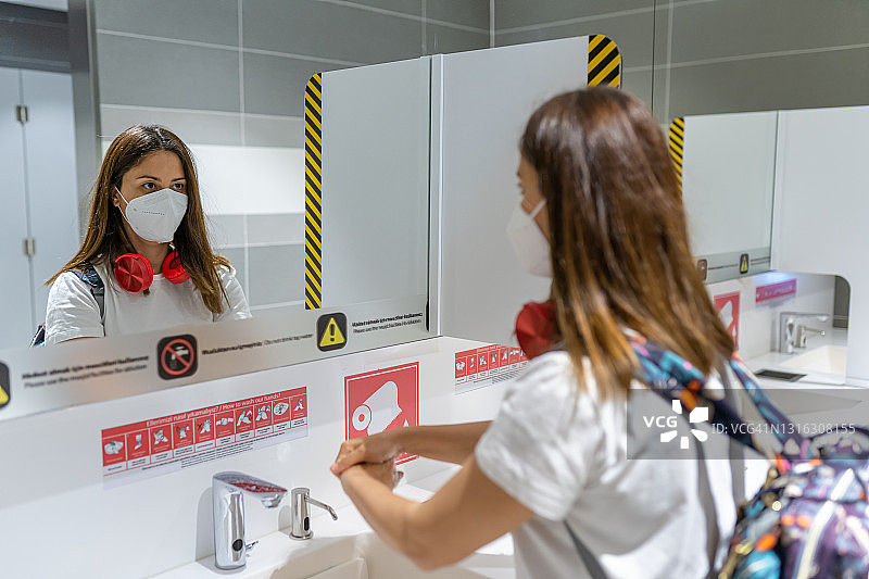 年轻旅行者在机场飞行前对手部进行消毒图片素材