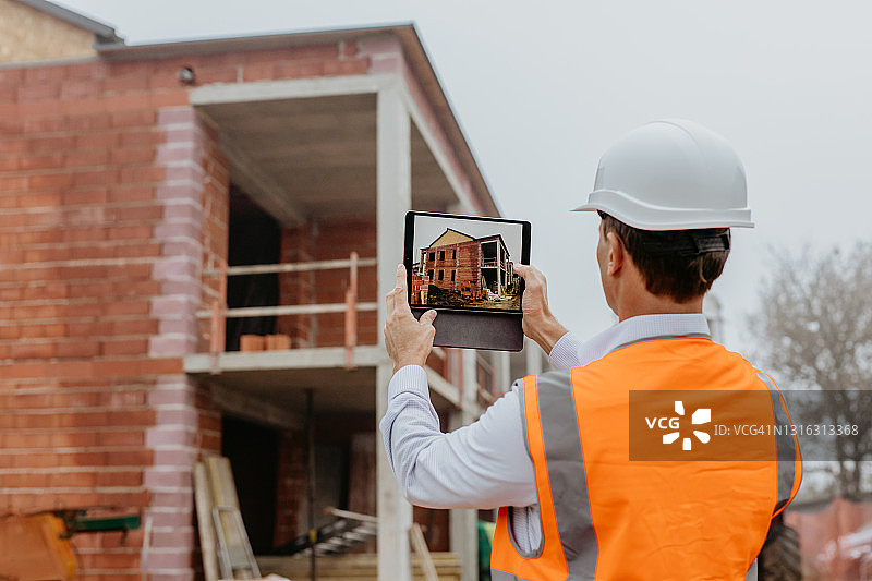 在建筑工地使用数位板拍摄开发的男建筑师图片素材