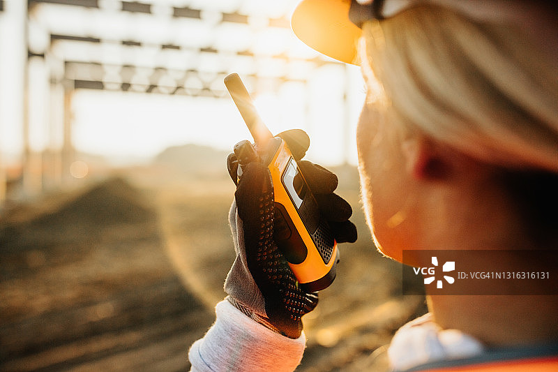 女工程师在建筑工地用对讲机讲话图片素材