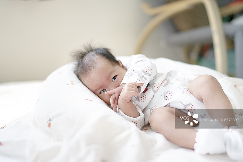 舒适床上亚洲新生儿的面部表情特写及留白图片素材