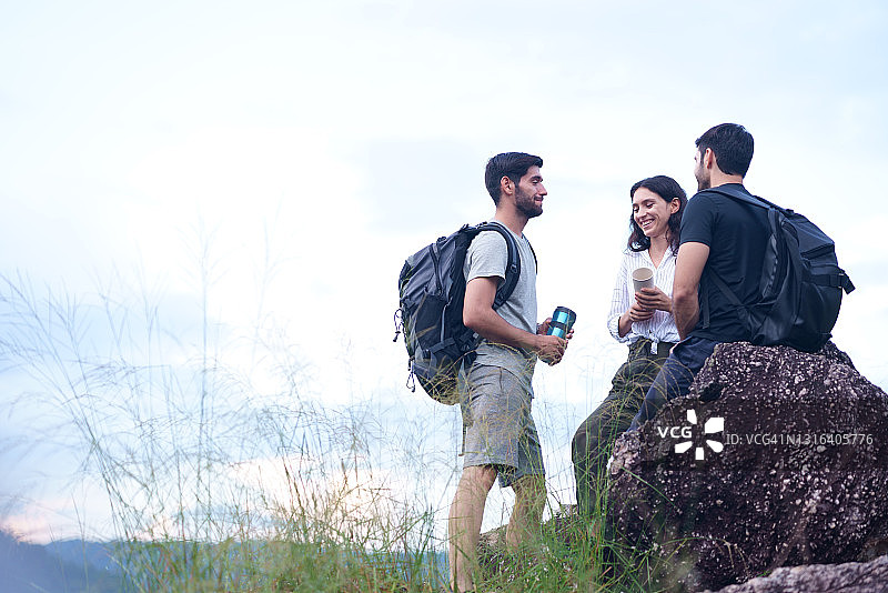 一群背包客朋友坐在山上休息图片素材