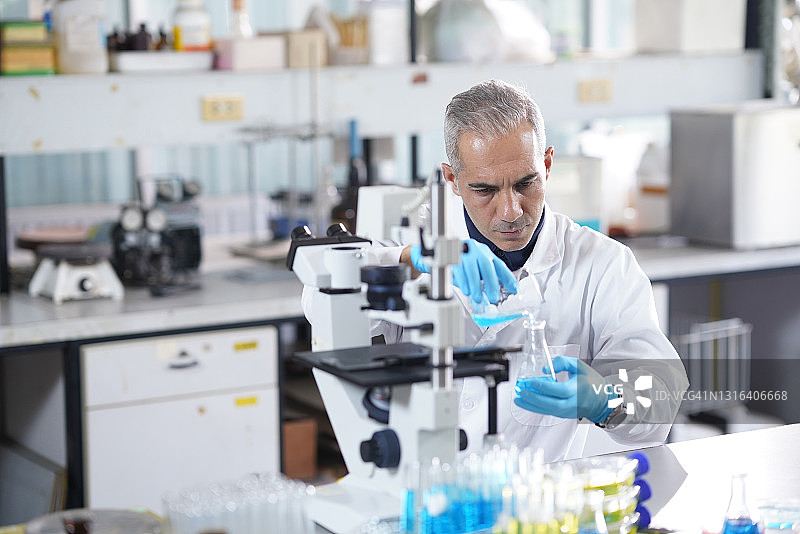 化学家在化学实验室中混合液体化学样品图片素材