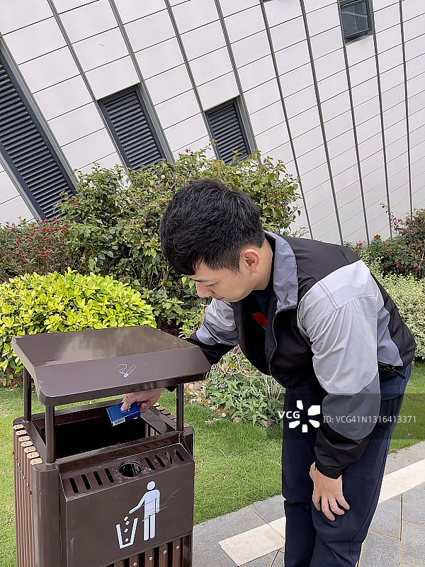 一位年轻的中国男子正在扔掉香烟盒图片素材