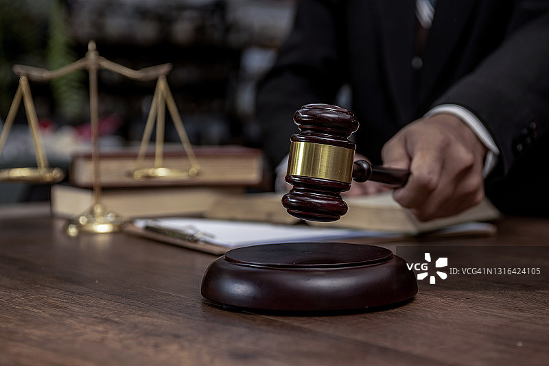 男人手持木槌敲击，法律与拍卖概念图片素材
