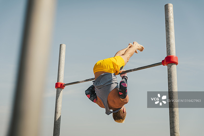 在高杠上进行体操的运动员图片素材