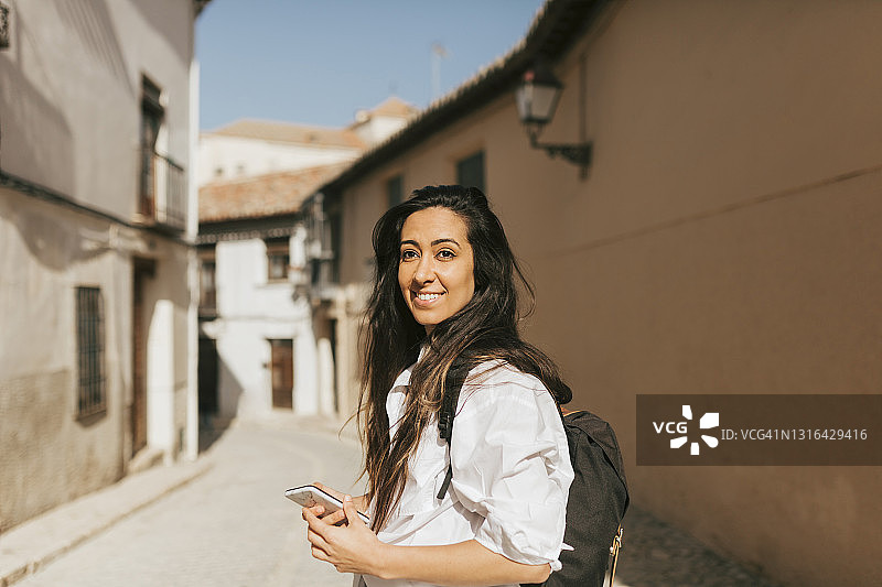 带着背包和手机的女游客图片素材
