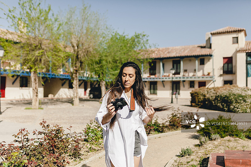 晴天在村庄用相机拍摄的女游客图片素材