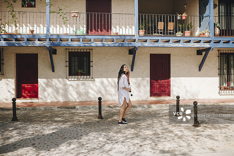 在晴朗的日子里站在走道上的女人图片素材