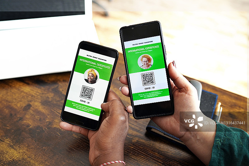 白人女性和非洲裔女性展示电子疫苗接种通行证图片素材