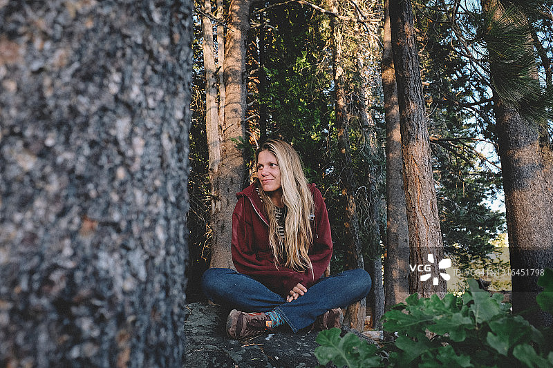 在森林中平静地坐着的金发女人图片素材