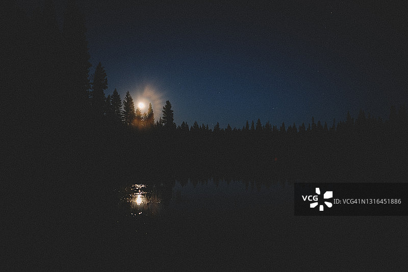 内华达山脉湖面上方发光的月出：海军蓝天空图片素材