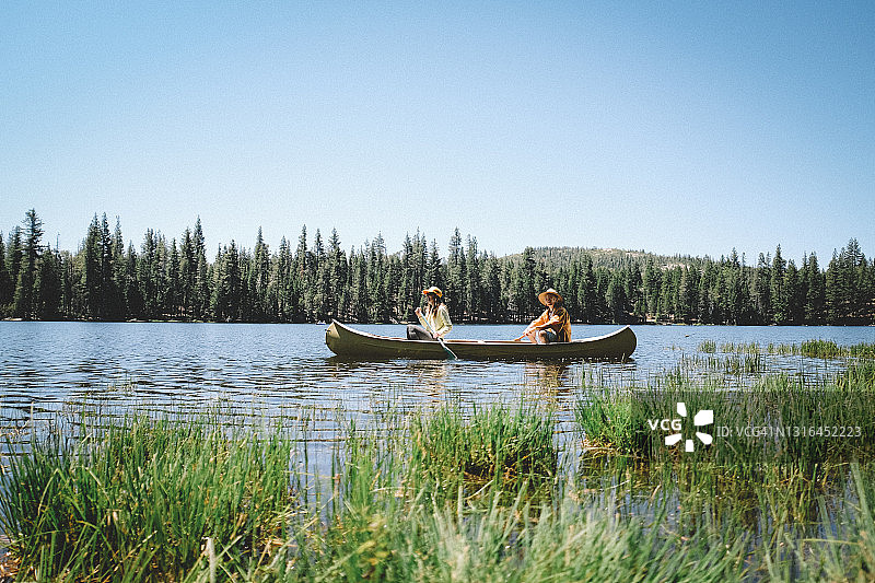 母子同划黄色独木舟，塞拉湖美景图片素材