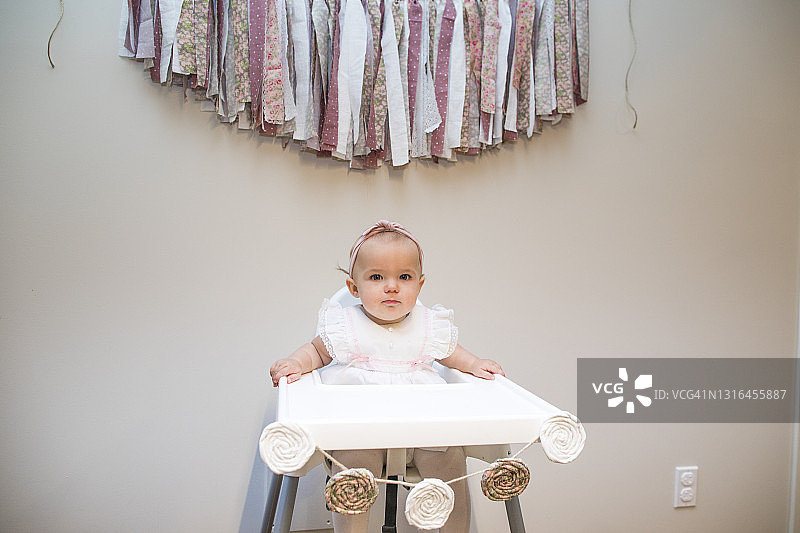 女婴周岁生日，坐在生日banner下图片素材