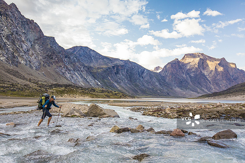 登山者在山口中穿越汹涌的河流图片素材